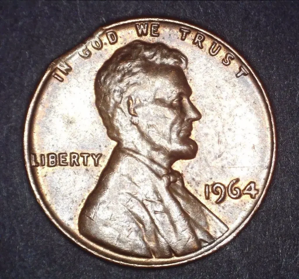 1964 Lincoln cent with a clipped planched on the left side.